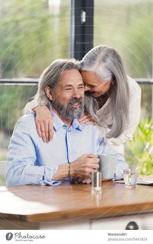 Glückliches älteres Ehepaar trinkt zu Hause Kaffee glücklich glücklich sein glücklichsein genießen geniessen Genuss Paar Pärchen Paare Partnerschaft Gemeinsam