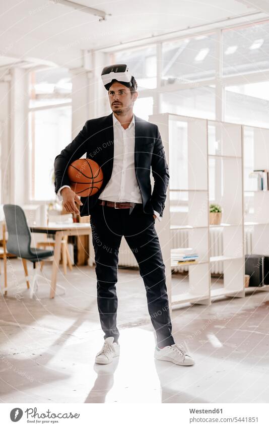 Geschäftsmann mit VR-Brille hält Basketball im Amt 3D Brille 3D-Brille Businessmann Businessmänner Geschäftsmänner Mann Männer männlich dreidimensional 3-D 3-d