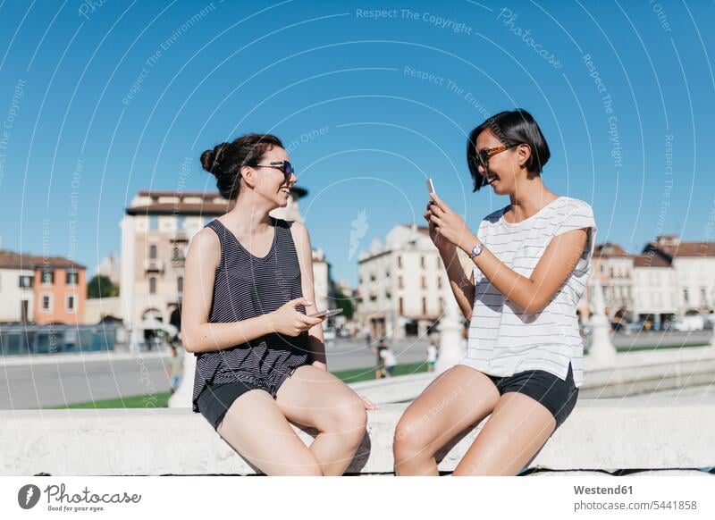 Italien, Padua, junge Frau, die ihren Freund mit einem Smartphone fotografiert Freundinnen iPhone Smartphones fotografieren Freunde Freundschaft Kameradschaft