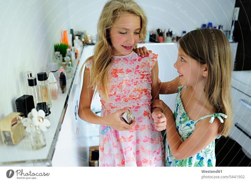 Zwei Mädchen tragen Parfüm im Badezimmer auf lächeln weiblich Freundinnen Parfum Flakons Parfumflasche Parfümflasche Kind Kinder Kids Mensch Menschen Leute