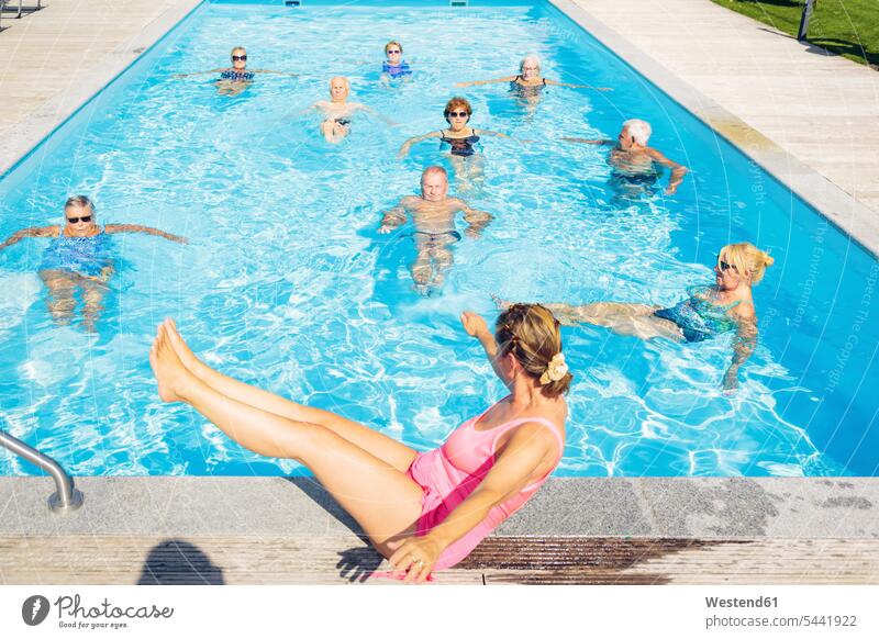 Gruppe von Senioren mit einem Trainer, der Wassergymnastik im Schwimmbad macht alte ältere Gruppe von Menschen Menschengruppe Swimmingpool Swimmingpools