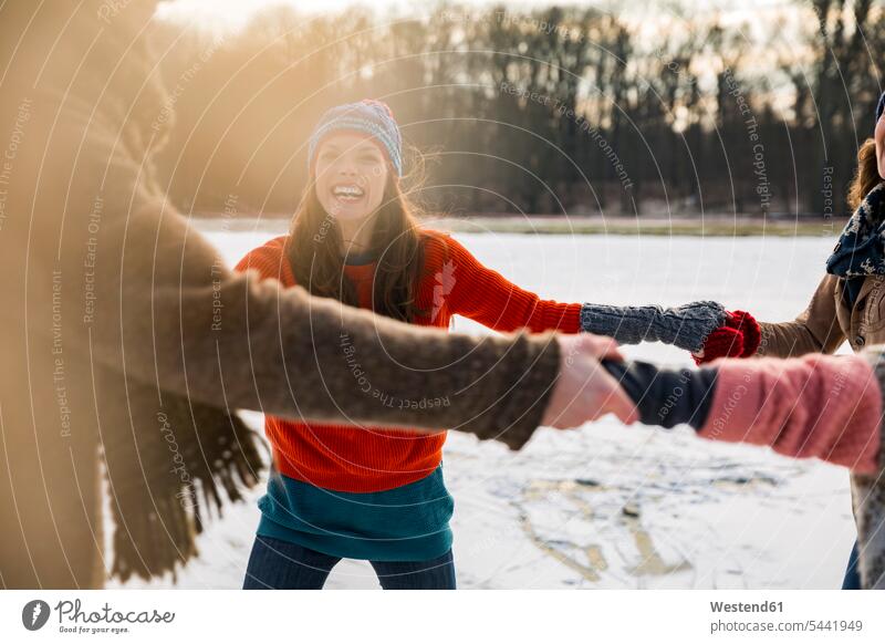 Freunde eislaufen im Kreis auf einem gefrorenen See schlittschuhlaufen lachen glücklich Glück glücklich sein glücklichsein Schlittschuhläufer
