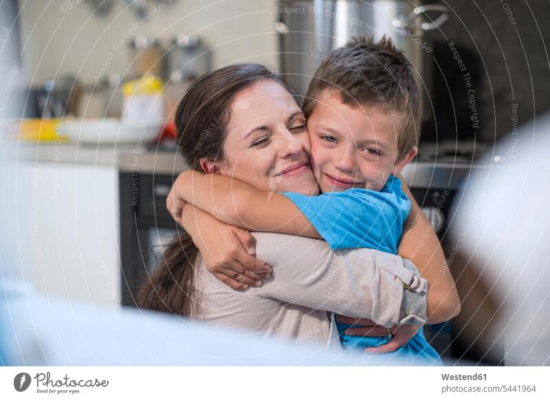 Mutter und Sohn umarmen sich in der Küche Küchen Umarmung Umarmungen Arm umlegen Mami Mutti Mütter Mama Söhne Eltern Familie Familien Mensch Menschen Leute