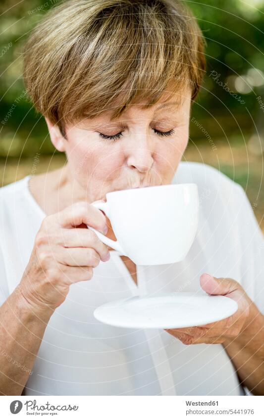 Ältere Frau trinkt eine Tasse Kaffee im Freien Seniorin älter Seniorinnen alt weiblich Frauen trinken Senioren Erwachsener erwachsen Mensch Menschen Leute