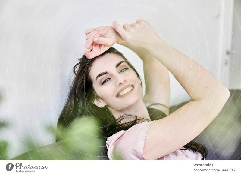 Porträt einer lächelnden jungen Frau zu Hause entspannt entspanntheit relaxt Spaß Spass Späße spassig Spässe spaßig weiblich Frauen Entspannung relaxen