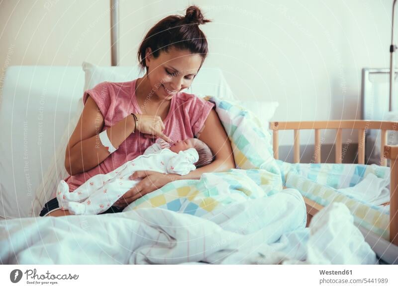 Glückliche Mutter mit ihrem Neugeborenen im Krankenhausbett Kliniken Krankenhäuser Krankenhaeuser Mami Mutti Mütter Mama Baby Babies Babys Säuglinge Kind Kinder