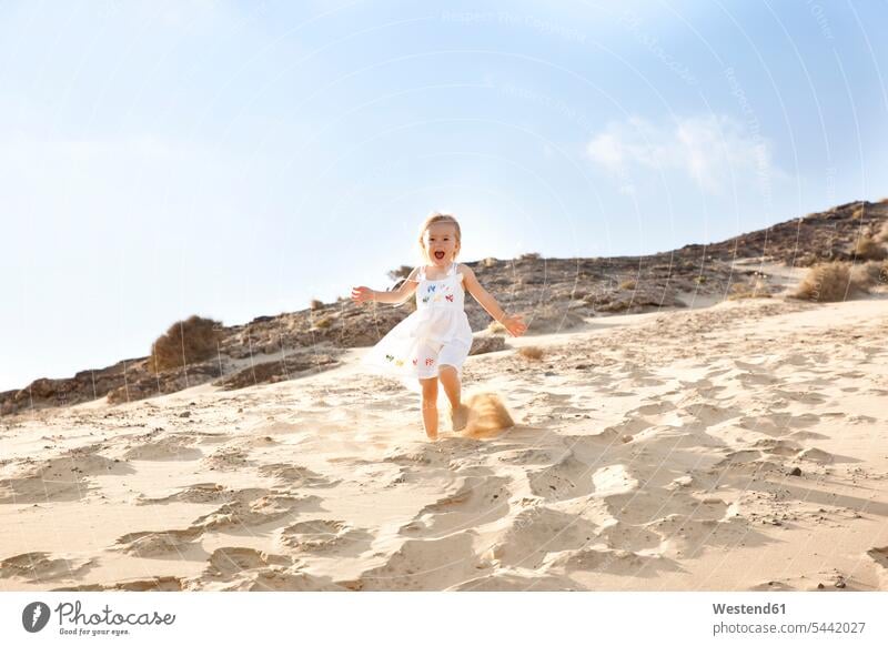 Spanien, Fuerteventura, Mädchen läuft am Strand eine Düne hinunter Spaß Spass Späße spassig Spässe spaßig glücklich Glück glücklich sein glücklichsein lachen