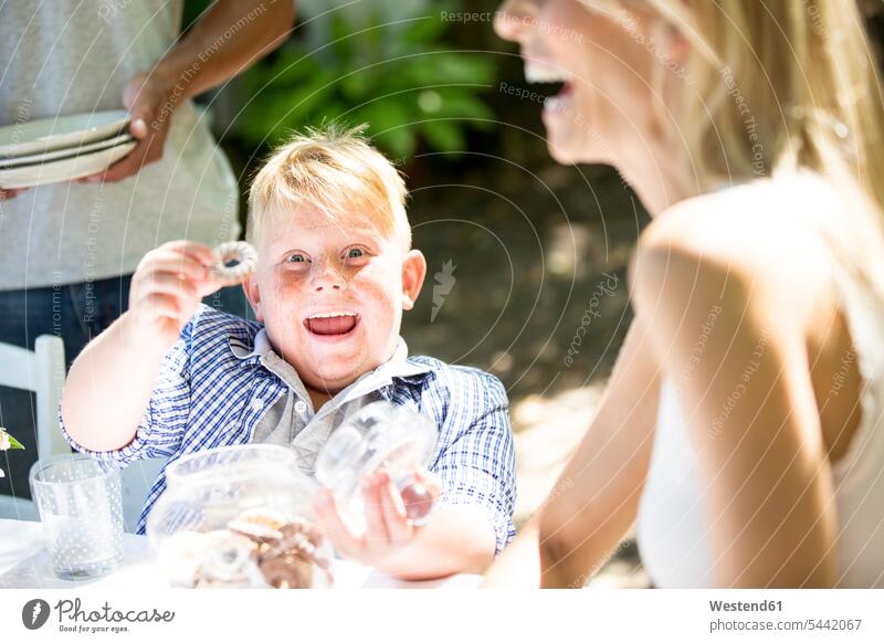 Porträt eines glücklichen Jungen mit Keksen essen essend Plaetzchen Plätzchen Buben Knabe Knaben männlich Gebäck Backware Gebaeck Backwaren Süßspeise Süsses