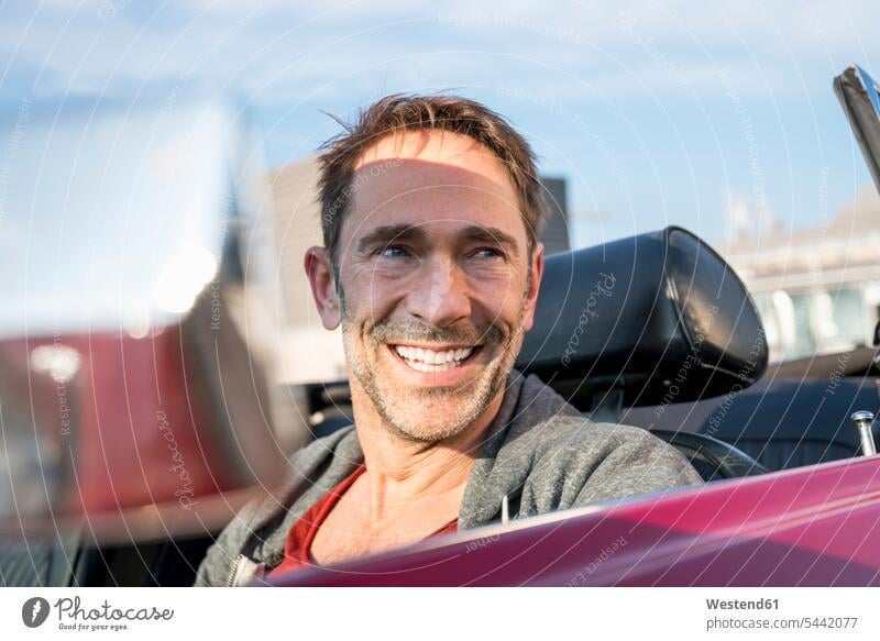 Porträt eines lächelnden reifen Mannes, der in seinem Sportwagen sitzt Portrait Porträts Portraits Männer männlich Cabrio Kabriolett Kabrios Cabriolet