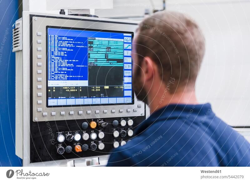 Mann schaut auf Bildschirm in Industriefabrik Fabrik Fabriken arbeiten Arbeit Monitor Screen Monitore Bildschirme Screens prüfen Kontrolle Untersuchung