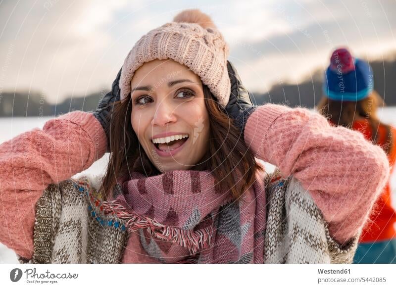 Glückliche Frau hält ihren Wollhut Wollmütze Wollmützen Strickmütze Strickmützen glücklich glücklich sein glücklichsein weiblich Frauen lächeln Mütze Mützen