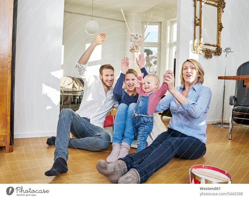 Glückliche Familie mit spielendem Mädchen im Wohnzimmer lächeln Familien Baby Babies Babys Säuglinge Kind Kinder glücklich glücklich sein glücklichsein Mensch