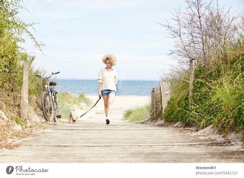 Junge Frau geht mit ihrem Hund spazieren weiblich Frauen Strand Beach Straende Strände Beaches Hunde Erwachsener erwachsen Mensch Menschen Leute People Personen