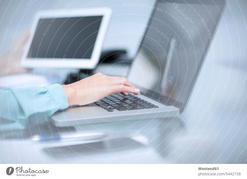Geschäftsfrau benutzt Laptop, hält digitales Tablett tippen Business Geschäftsleben Geschäftswelt geschäftlich Laptop benutzen Laptop benützen Beruf