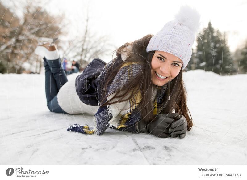 Frau mit Schlittschuhen auf Schnee liegend Winter winterlich Winterzeit weiblich Frauen Schlittschuhlaufen Eislaufen Spaß Spass Späße spassig Spässe spaßig