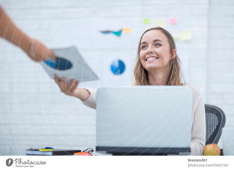 Junge Frau, die im Büro arbeitet und Dokumente entgegennimmt Büroangestellte arbeiten Arbeit glücklich Glück glücklich sein glücklichsein nehmen aufnehmen