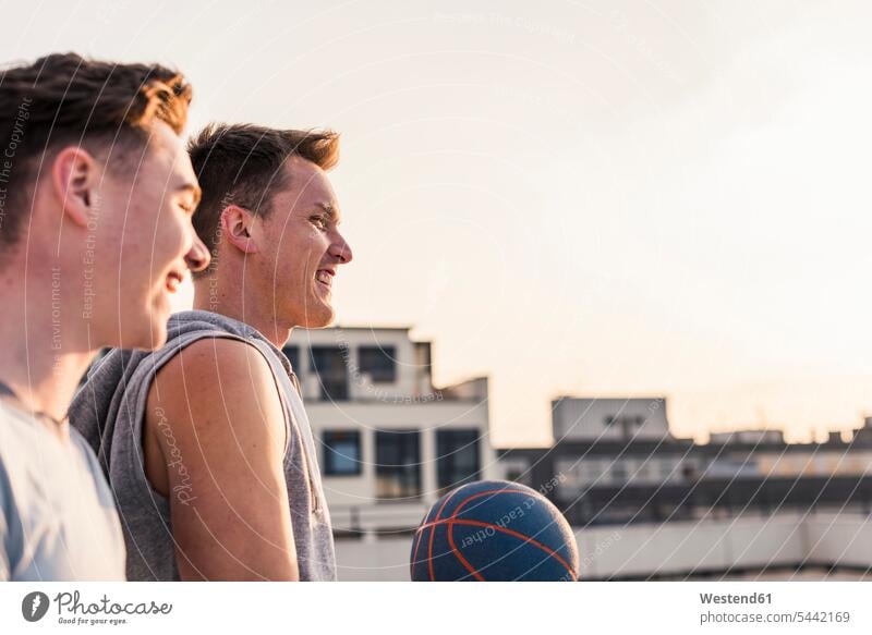 Freunde spielen bei Sonnenuntergang auf einem Dach Basketball jung Basketbaelle Basketbälle glücklich Glück glücklich sein glücklichsein Spaß Spass Späße