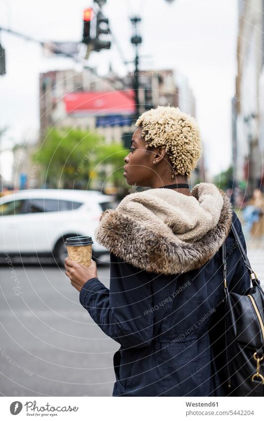 USA, New York City, modische junge Frau mit Kaffee zum Mitnehmen, die am Straßenrand wartet Coffee to go zum mitnehmen weiblich Frauen warten Straßenränder