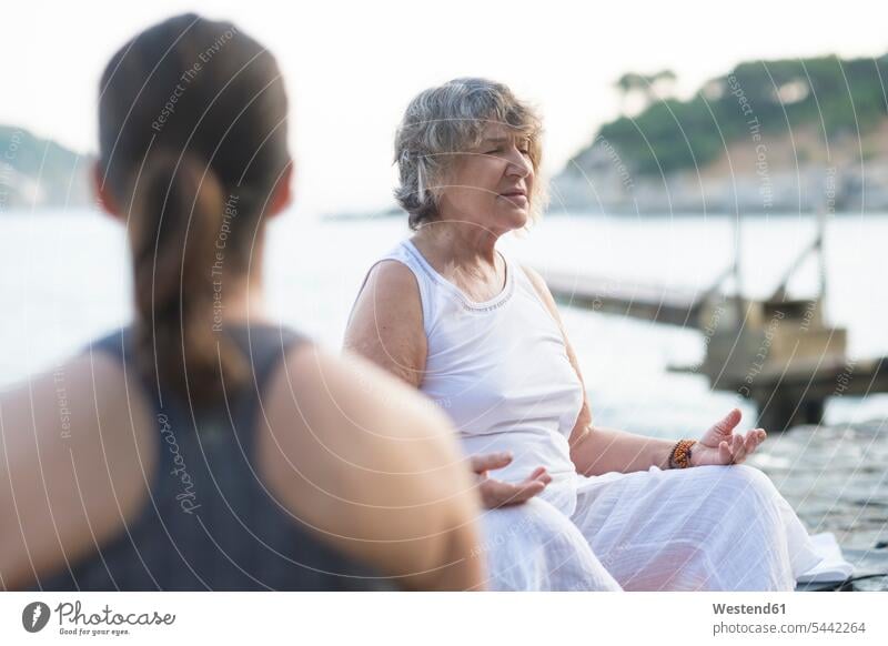 Ältere Frau macht eine Yoga-Übung an der Küste weiblich Frauen Kueste Kuesten Küsten Seniorin älter Seniorinnen alt meditieren üben ausüben trainieren