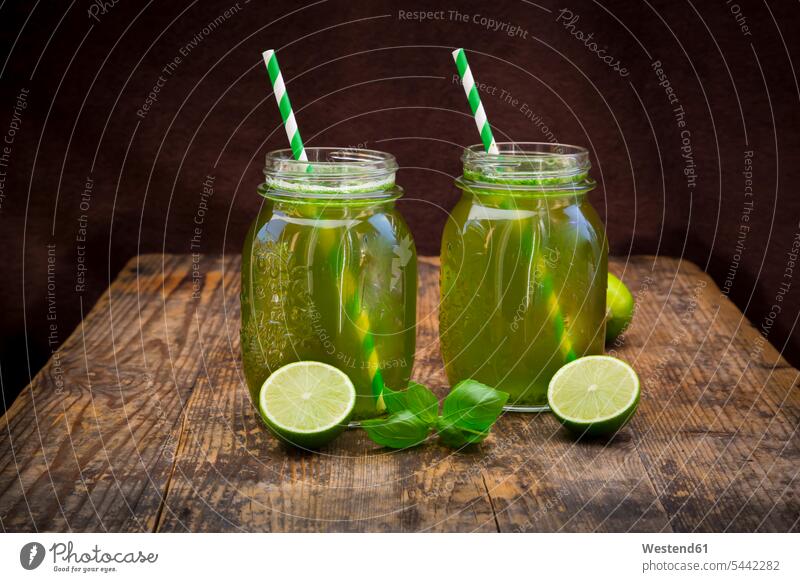 Zwei Gläser Bio-Limettenlimonade mit Basilikum Glas hölzern Hälfte halbe halbiert halber Haelfte zubereitet Aroma aromatisch angerichtet garniert servierfertig