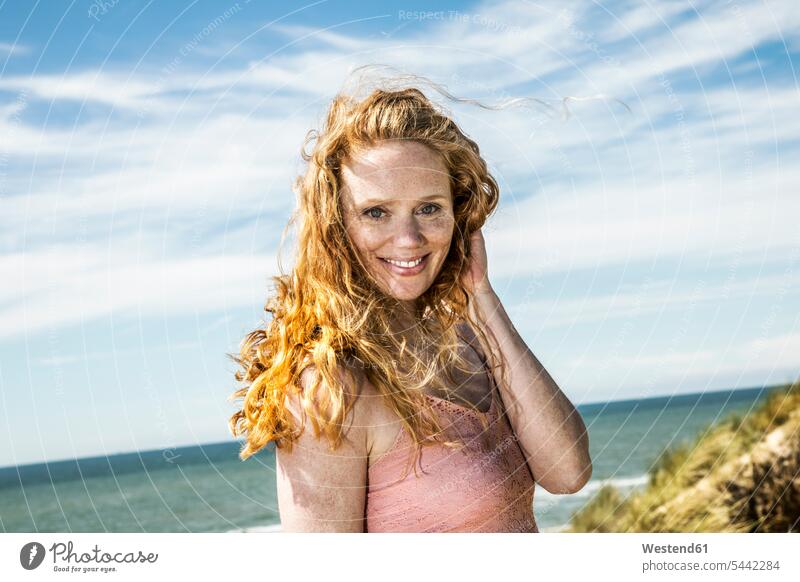 Niederlande, Zandvoort, Porträt einer lächelnden Frau an der Küste Strand Beach Straende Strände Beaches Portrait Porträts Portraits weiblich Frauen Erwachsener