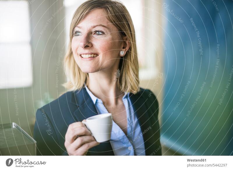 Lächelnde Geschäftsfrau mit Espressotasse im Amt lächeln Geschäftsfrauen Businesswomen Businessfrauen Businesswoman Büro Office Büros Kaffee Geschäftsleute