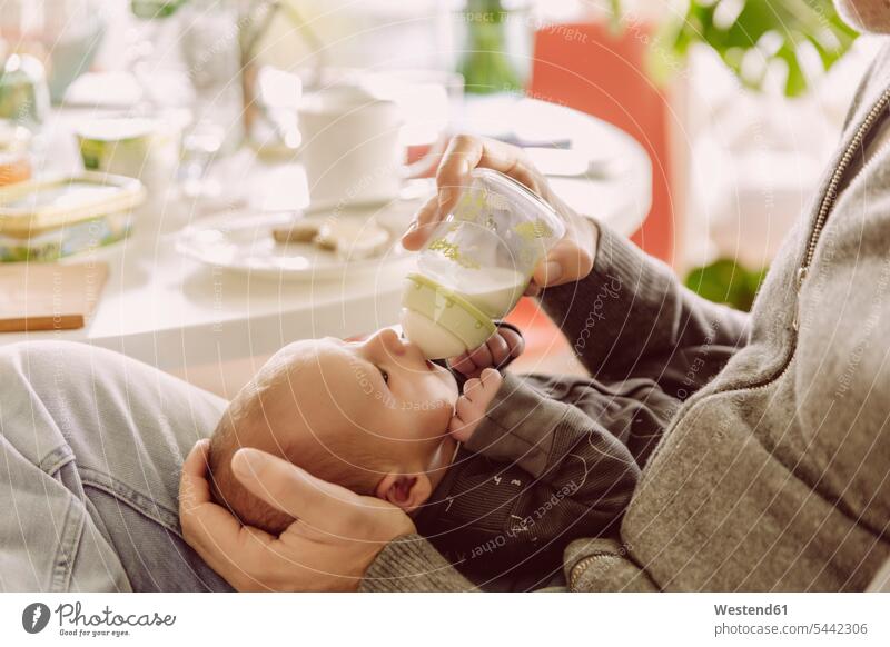 Vater füttert sein Neugeborenes mit der Flasche Papas Väter Vati Vatis Papis Babyflasche Babyflaschen Flaeschchen Saugflasche Fläschchen Milchflaschen