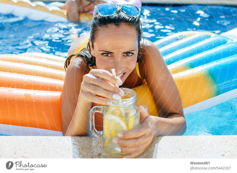 Junge Frau im Schwimmbad mit Getränk am Poolrand entspannt entspanntheit relaxt weiblich Frauen Swimmingpool Swimmingpools Schwimmbecken Swimming Pool