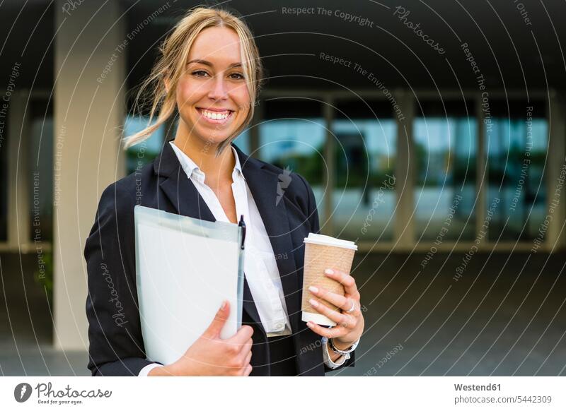 Porträt einer glücklichen Geschäftsfrau mit Dokumenten und Kaffee zum Mitnehmen Portrait Porträts Portraits Geschäftsfrauen Businesswomen Businessfrauen