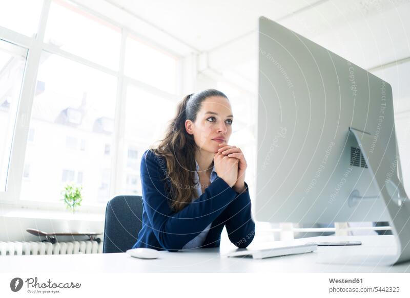 Am Schreibtisch arbeitende Geschäftsfrau Geschäftsfrauen Businesswomen Businessfrauen Businesswoman Frau weiblich Frauen sitzen sitzend sitzt Arbeit