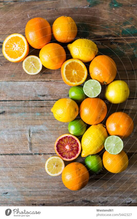 In Scheiben geschnittene und ganze Zitronen, Orangen und Limetten auf Holz vitaminreich verschieden verschiedene Kreis kreisförmig kreisfoermig Kreise Sorte