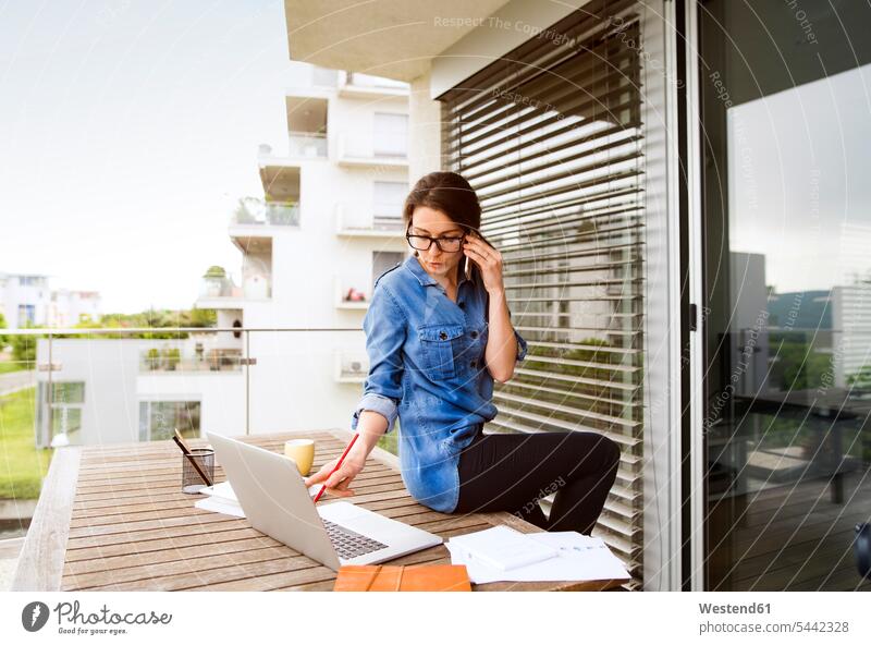 Geschäftsfrau am Telefon, die zu Hause auf dem Balkon arbeitet Freiberufler freiberuflich freie Berufe Home Office homeoffice zuhause zuhause arbeiten