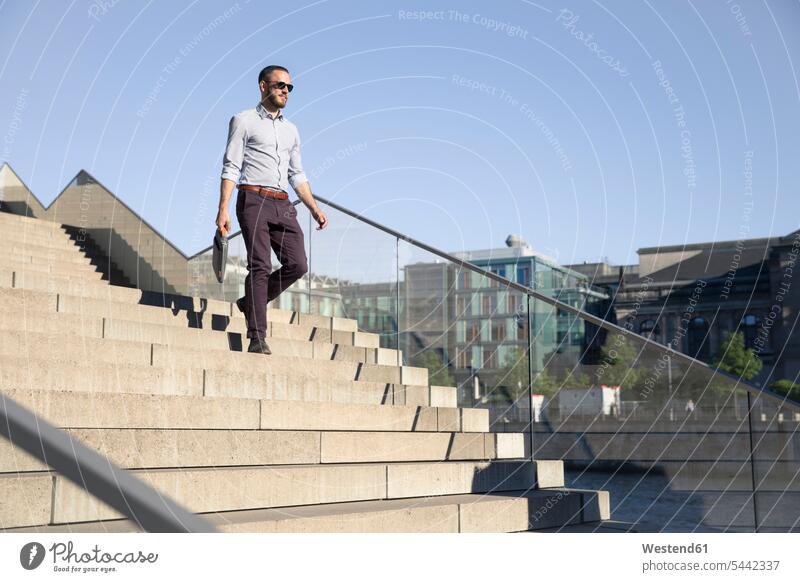 Geschäftsmann mit Sonnenbrille geht die Treppe hinunter Stadt staedtisch städtisch Businessmann Businessmänner Geschäftsmänner Treppenaufgang gehen gehend