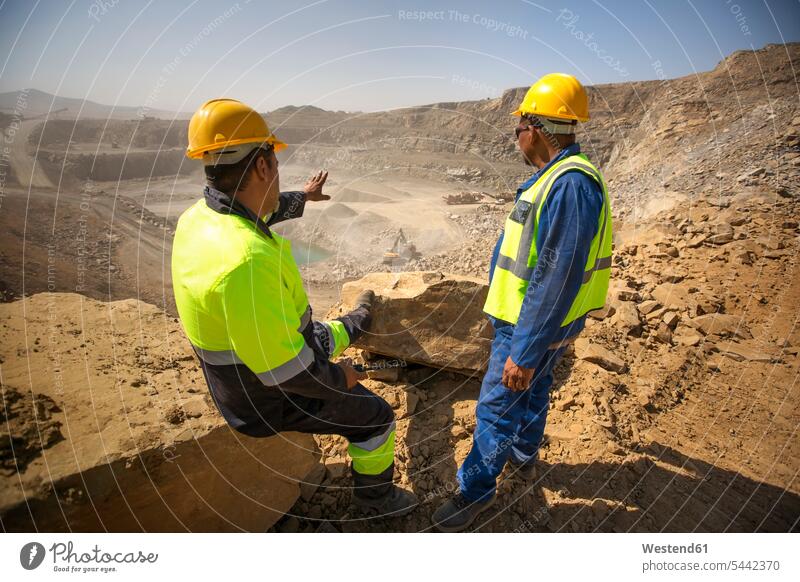 Zwei Steinbrucharbeiter schauen über den Steinbruch Tagebau Tagbau Kiesgrube Schottergrube Kiesgruben Schottergruben Schutzkleidung Schutzbekleidung Leuchtweste