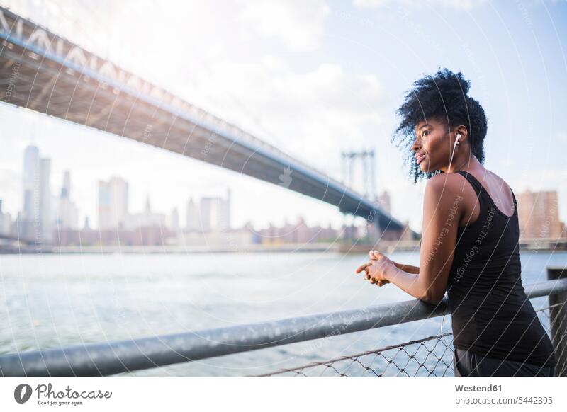USA, New York City, Brooklyn, Frau beim Musikhören in der Nähe der Manhattan Bridge weiblich Frauen hoeren Brücke Bruecken Brücken Erwachsener erwachsen Mensch