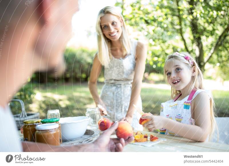 Glückliche Familie im Garten konserviert Pfirsiche Einweckglas Vorratsglas Einweckgläser Einmachgläser Einmachglaeser Einmachglas Einweckglaeser lächeln Tochter