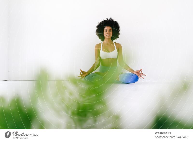 Fitte junge Frau, die Yoga praktiziert weiblich Frauen sitzen sitzend sitzt fit meditieren Training trainieren Lotussitz Lotusposition Lotuspositionen