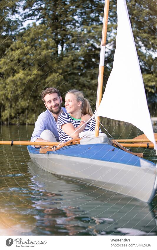 Ein glückliches junges Paar genießt eine Kanufahrt mit Segel Ausflug Ausflüge Kurzurlaub Ausfluege Pärchen Paare Partnerschaft Kanus Glück glücklich sein