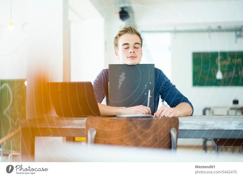 Porträt eines Studenten mit Laptop und Akte in einem Café Portrait Porträts Portraits Hochschueler Studierender Hochschüler Pause Mann Männer männlich Cafe
