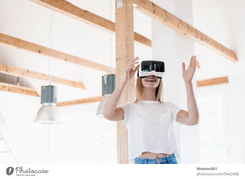 Junge Frau mit VR-Brille, die ihr neues Zuhause gestaltet Loft Lofts Planung Pläne planen Virtual Reality Brille Virtual-Reality-Brille Virtual Reality-Brille