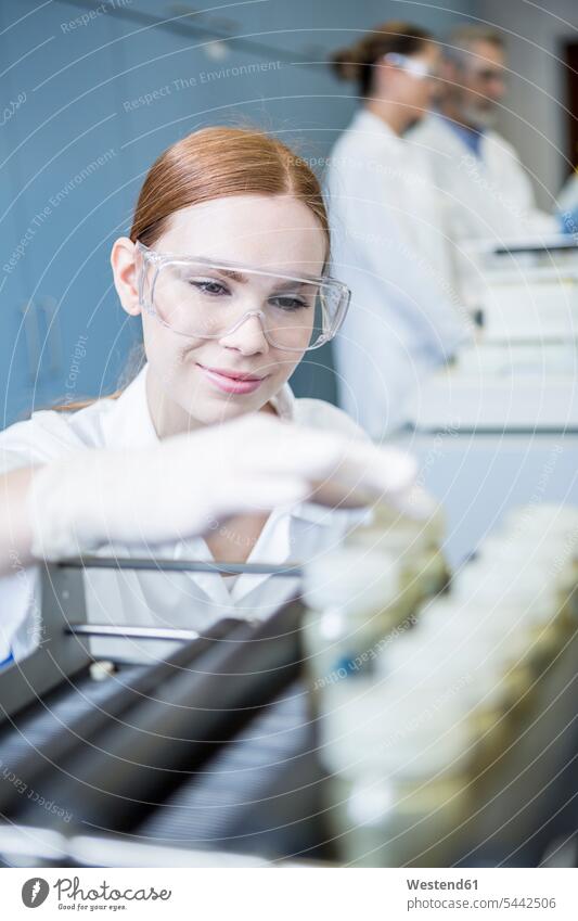 Lächelnder Wissenschaftler im Labor mit Proben Muster lächeln Frau weiblich Frauen Wissenschaftlerin Wissenschaftlerinnen wissenschaftlich Wissenschaften Labore