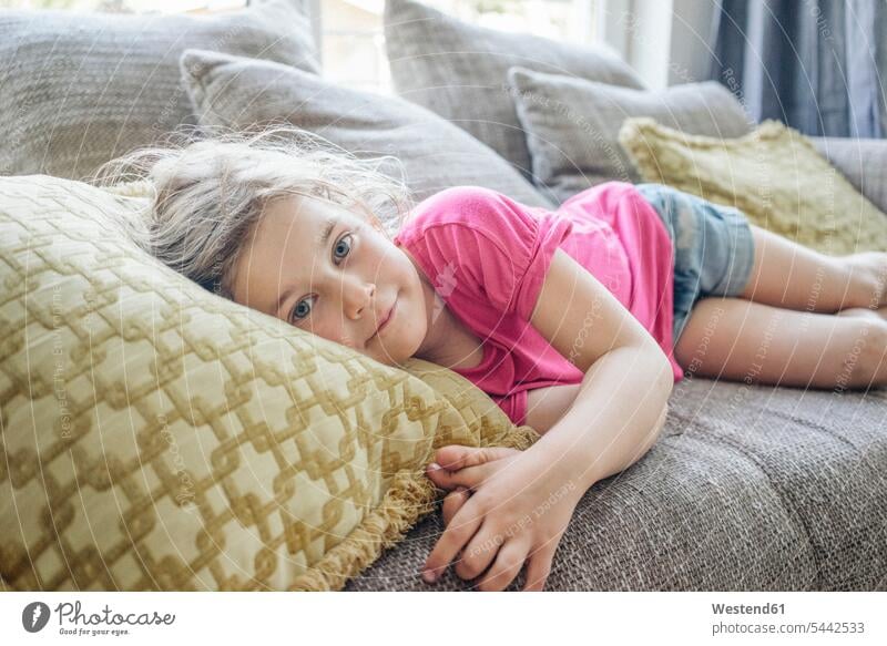 Porträt eines auf einer Couch liegenden Mädchens weiblich Sofa Couches Liege Sofas entspannt entspanntheit relaxt liegt Kind Kinder Kids Mensch Menschen Leute