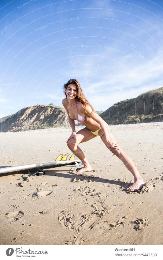 Glückliche Frau, die sich am Strand ausstreckt weiblich Frauen lächeln Beach Straende Strände Beaches Erwachsener erwachsen Mensch Menschen Leute People