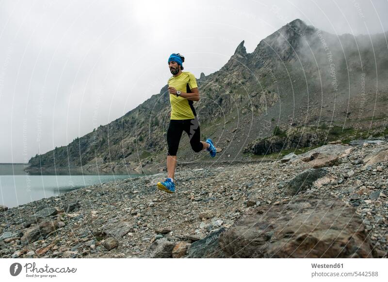 Italien, Alagna, Trailrunner unterwegs an einem See in der Nähe des Monte-Rosa-Gebirgsmassivs laufen rennen Sportler Berg Berge Mann Männer männlich Landschaft