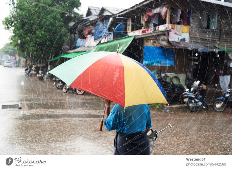 Myanmar, Rückenansicht eines Mannes unter einem Regenschirm nass Naesse Nässe Rückansicht Rueckansicht Rueckenansicht von hinten Tag am Tag Tageslichtaufnahme
