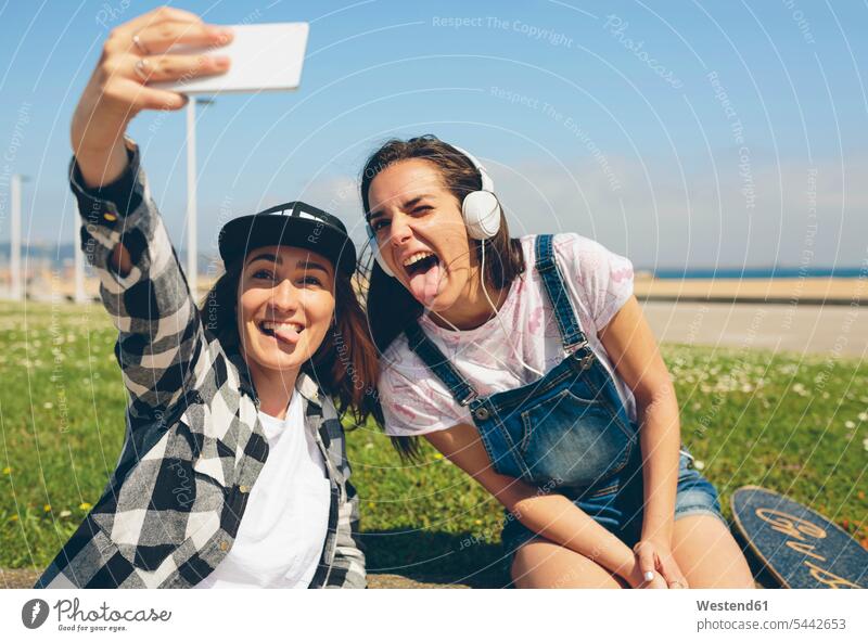 Porträt von zwei jungen Frauen, die ein Selfie mit einem Smartphone machen Selfies Portrait Porträts Portraits Freundinnen Freunde Freundschaft Kameradschaft