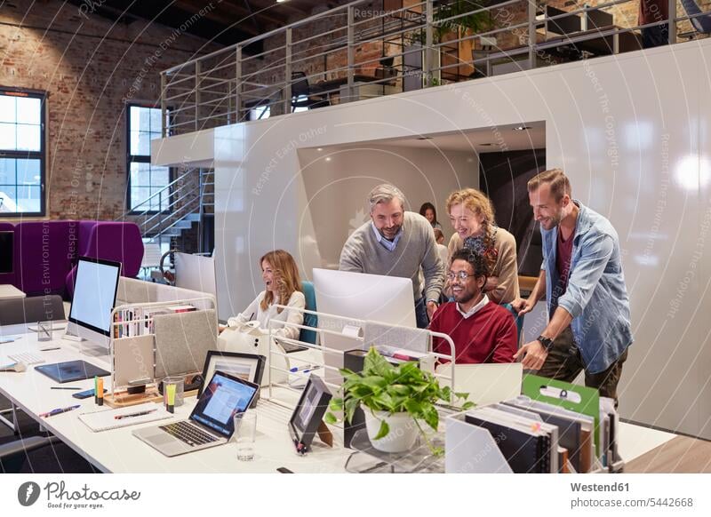Kollegen schauen einem jungen Mann über die Schulter, der in einem modernen Büro arbeitet Kollegin Kolleginnen Team Office Büros arbeiten Arbeit PC