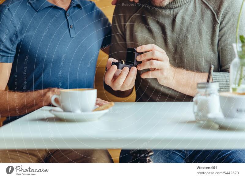 Nahaufnahme eines schwulen Paares mit Ehering im Cafe Kaffeehaus Bistro Cafes Café Cafés Kaffeehäuser Homosexueller Mann Homosexuelle Maenner Schwuler