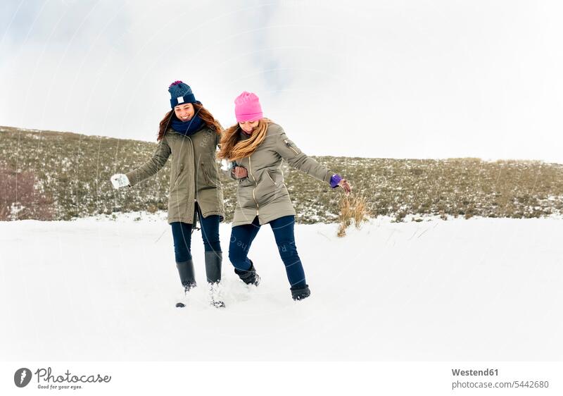 Zwei Freunde amüsieren sich im Schnee Freundinnen Winter winterlich Winterzeit Freundschaft Kameradschaft lachen Wetter positiv Emotion Gefühl Empfindung