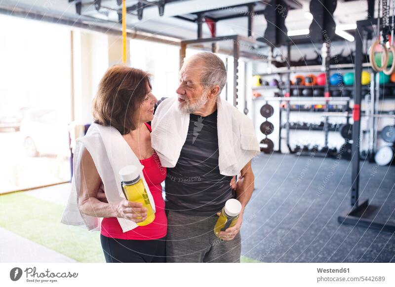 Fitnesspaar der Senioren im Fitnessstudio macht eine Pause Fitnessclubs Fitnessstudios Turnhalle lächeln trainieren Paar Pärchen Paare Partnerschaft alte ältere